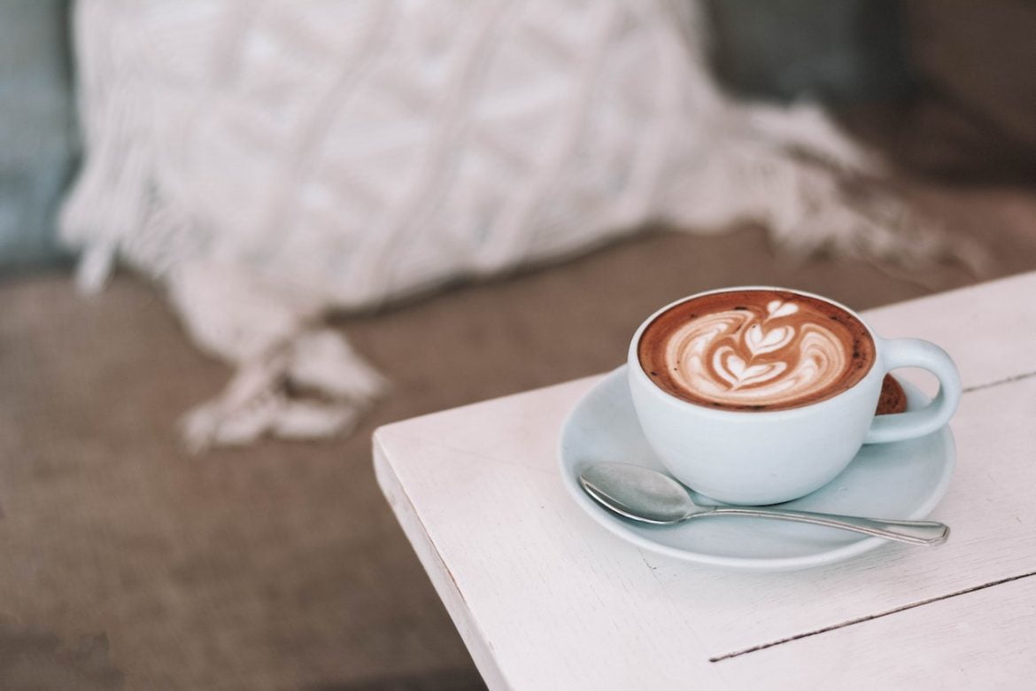Schön angerichteter Cappuccino mit Muster in einer gemütlichen Herbstumgebung, der den Blog-Post über die Top 5 perfekter Geschenkideen für Kaffeeliebhaber präsentiert.