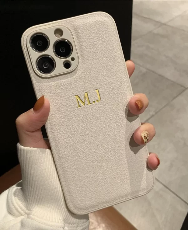 Frauenhand die eine Personalisierte iPhone Lederhülle mit individuellen Initialen für verschiedene iPhone-Modelle